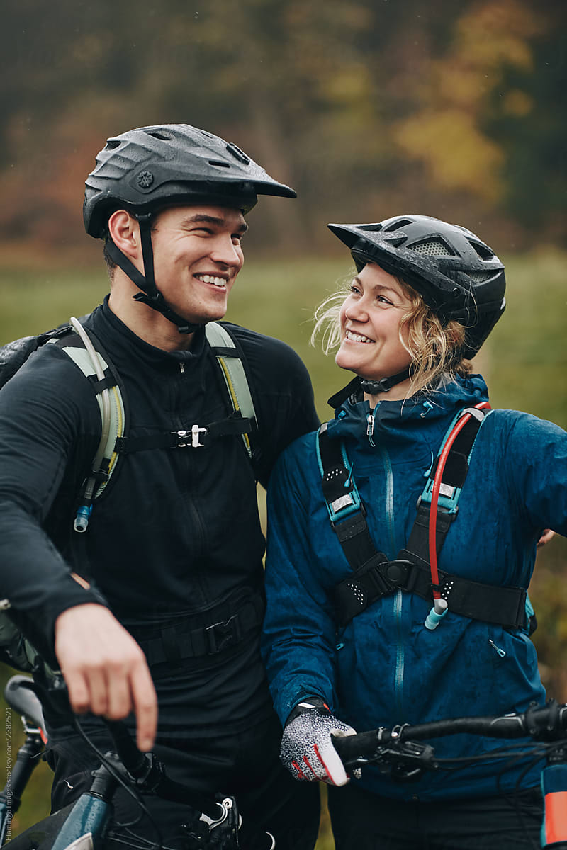 Smiling young couple ready to go mountain biking together