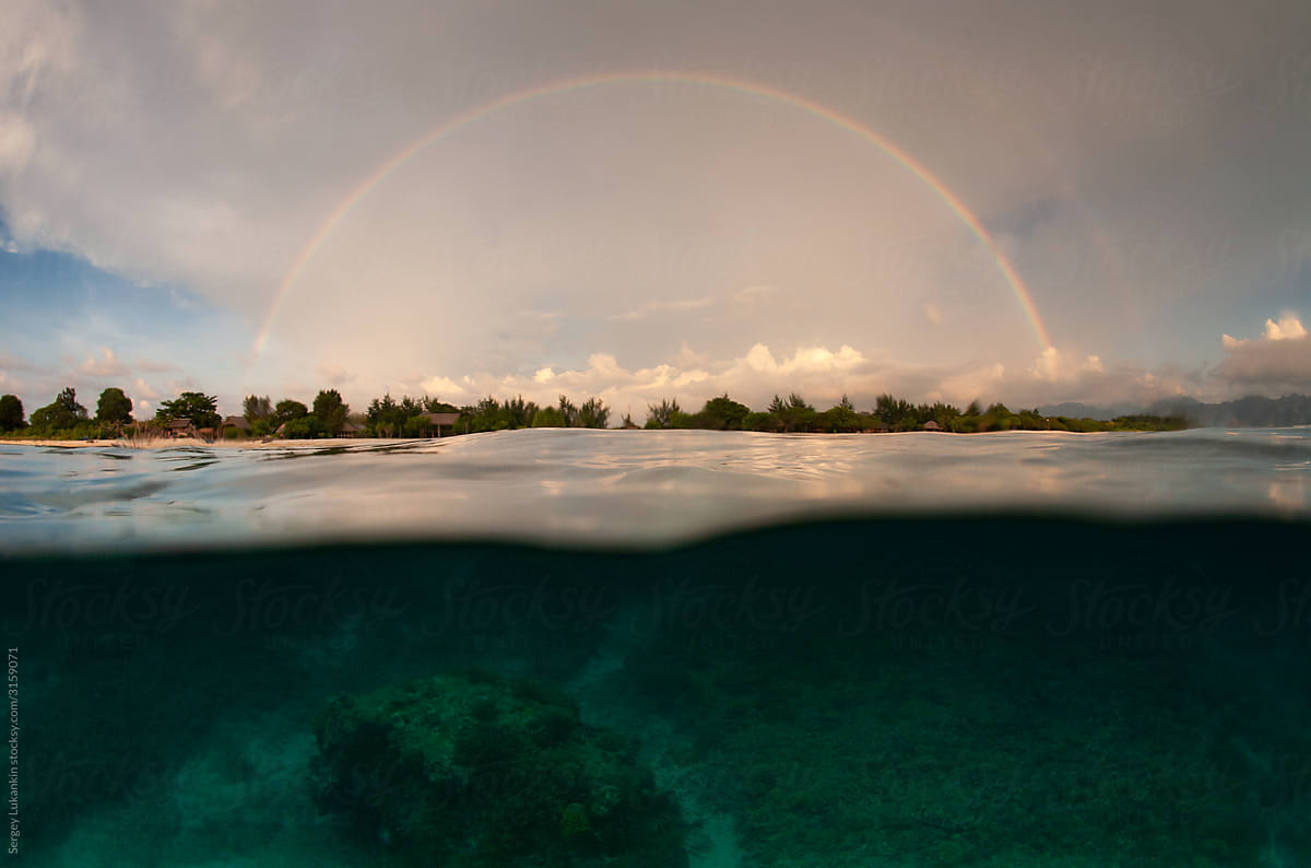 Split photo. View of the tropical island and rainbow from the water