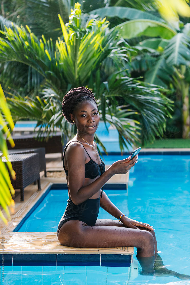 Slender African lady wearing swimsuit on poolside