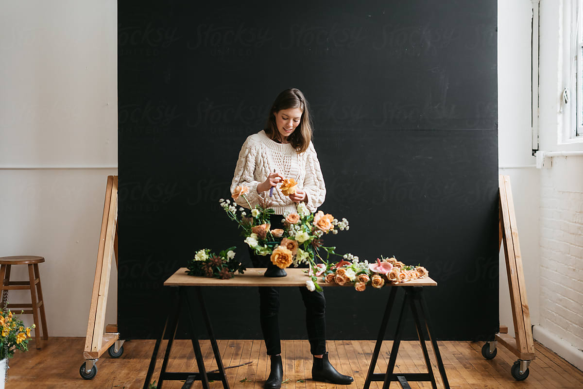 Florist in studio building a stunning floral arrangement