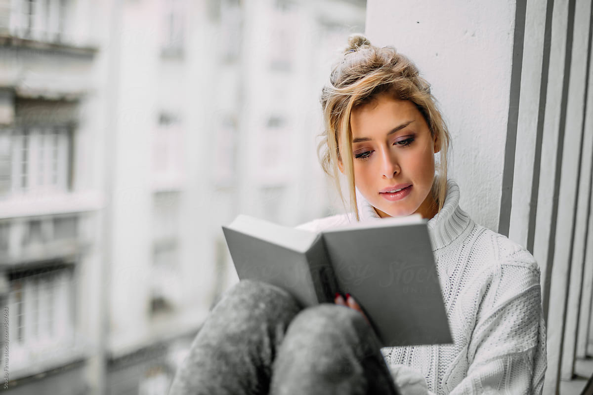 Beautiful Blonde Woman Reading A Book At Her Home Balcony Del