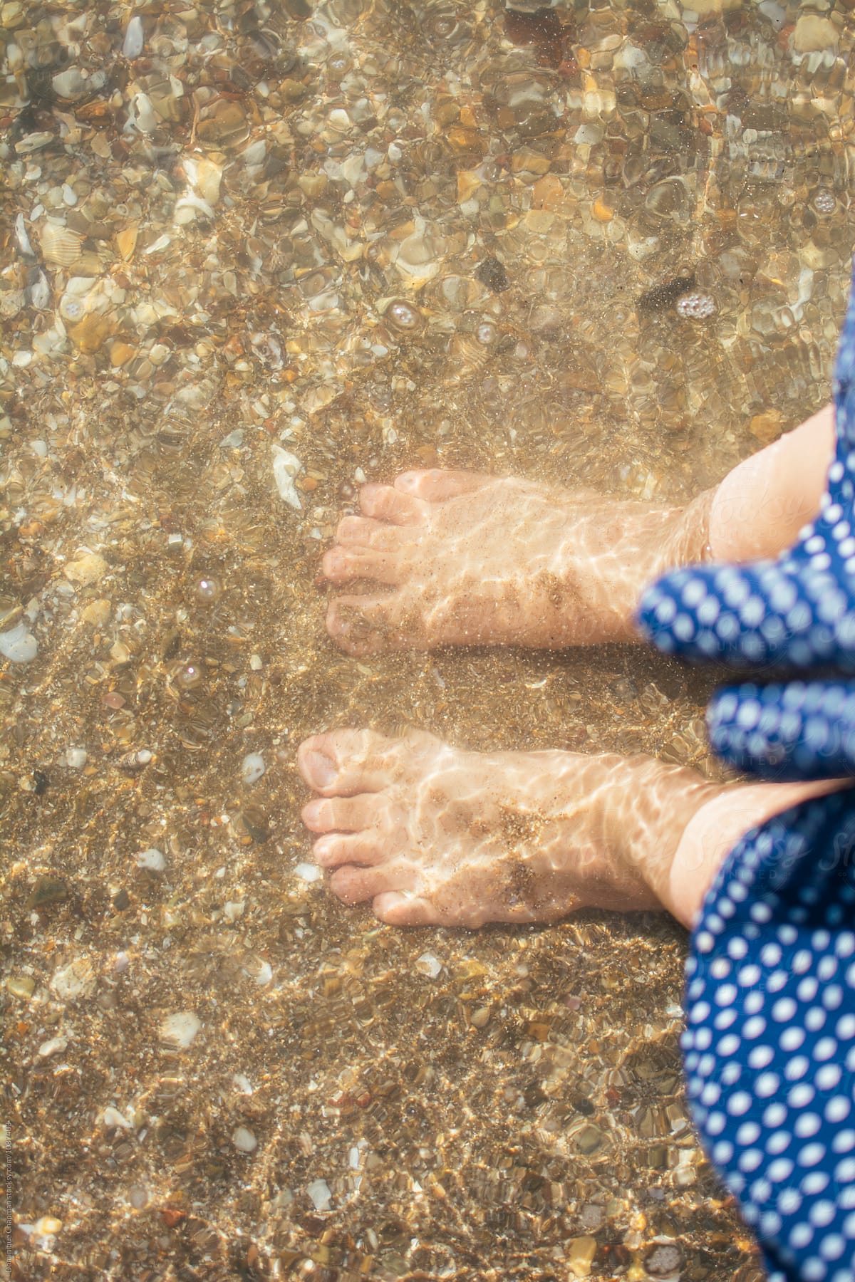 Woman\'s feet in clear ocean