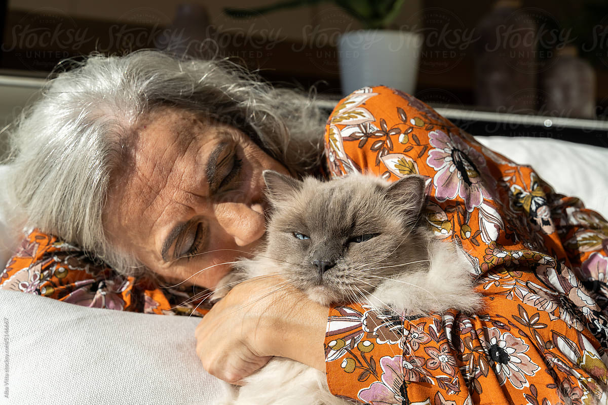 Mature woman kissing cat