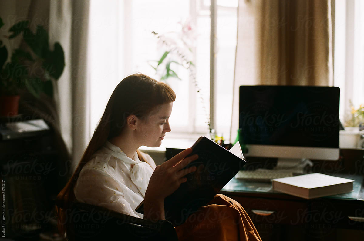 Young woman reading a book at home