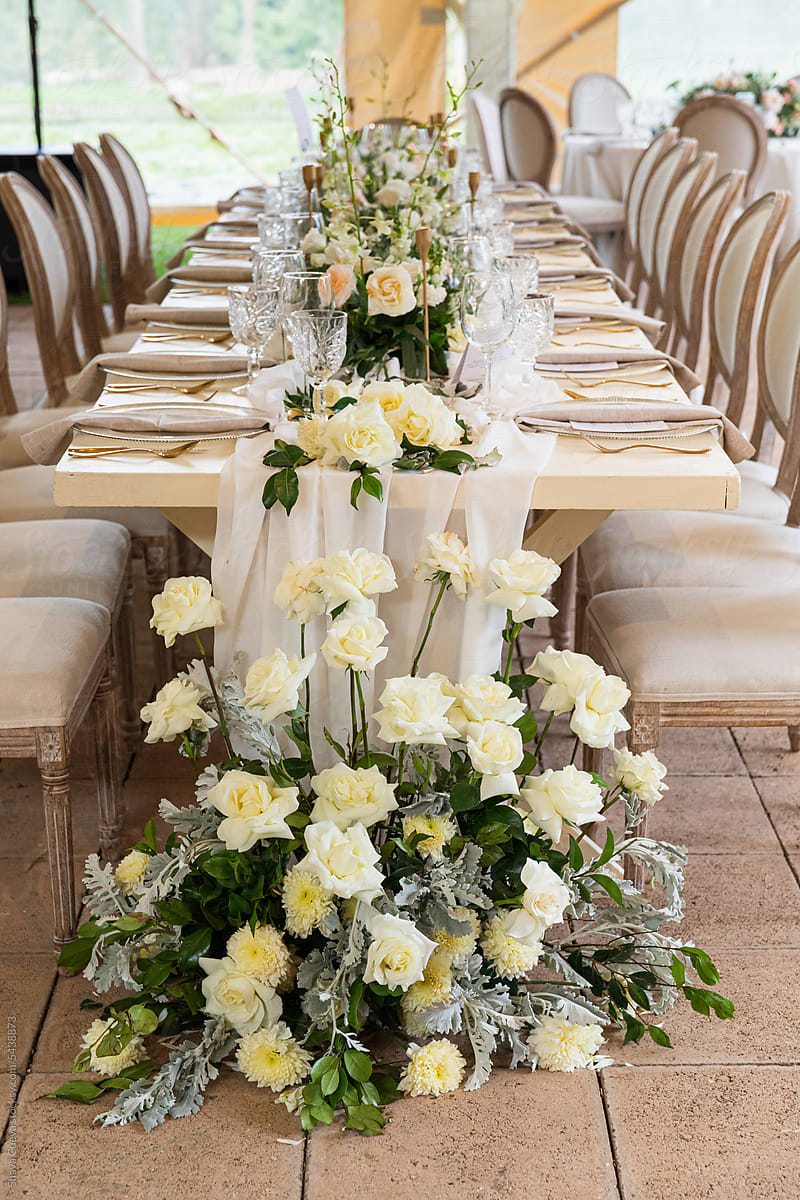 A withe rose ornament at a wedding table with chairs