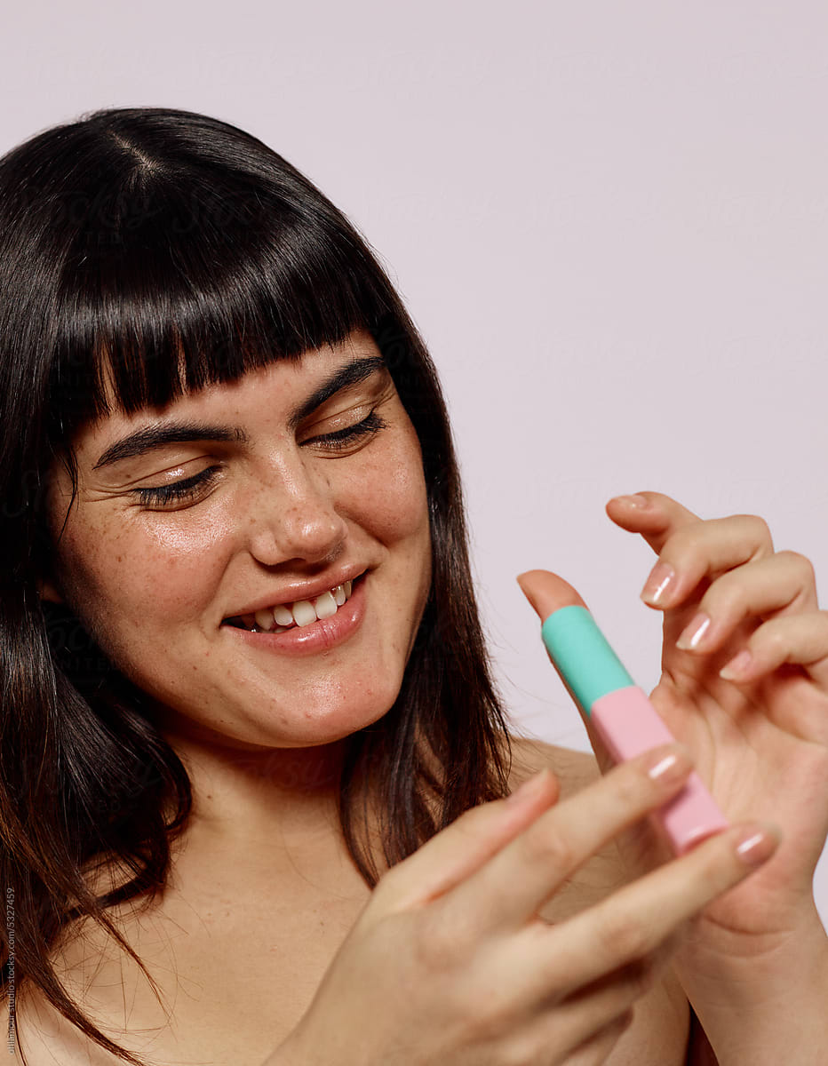 Happy Woman holding lipgloss product