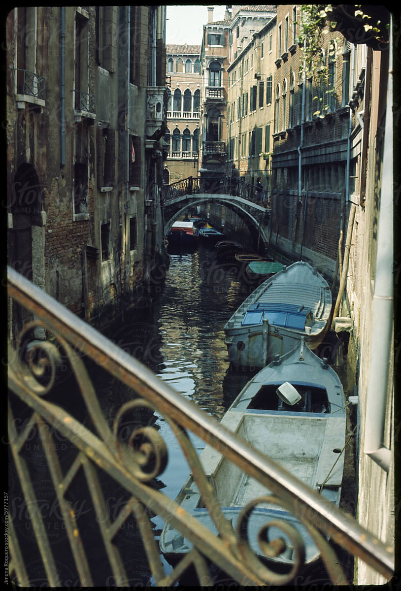 Old 70's film photo. Cityscape of Venice canal with boats parked