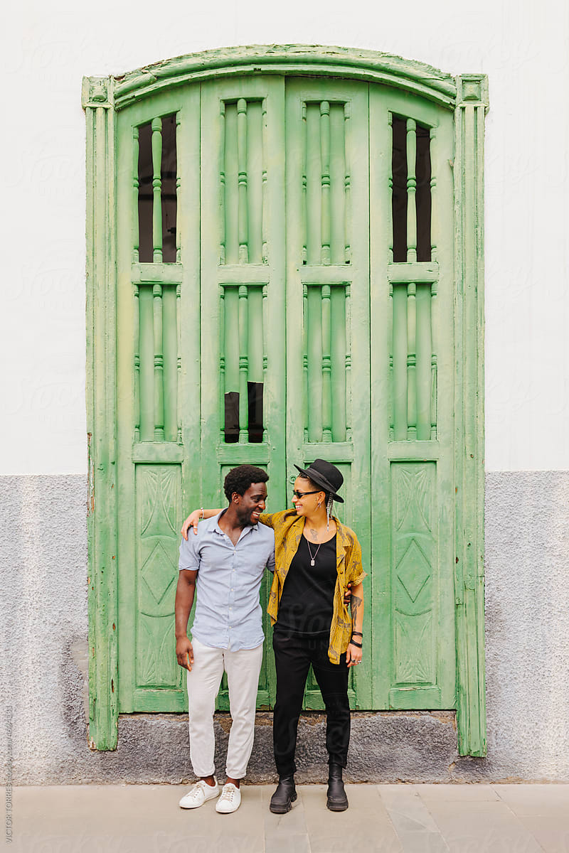 Young couple standing near entrance of old colonial building