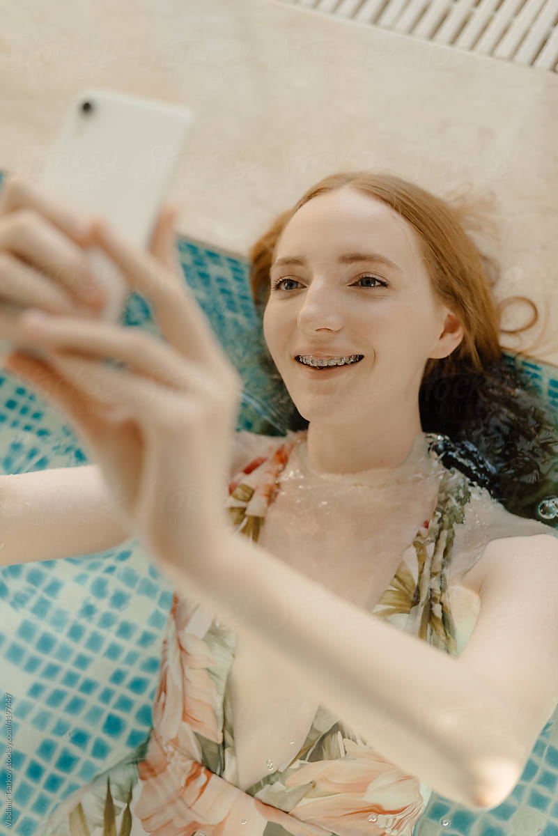 Cheerful Female With Braces Taking Selfie In Pool By Stocksy Contributor Vladimir Tsarkov