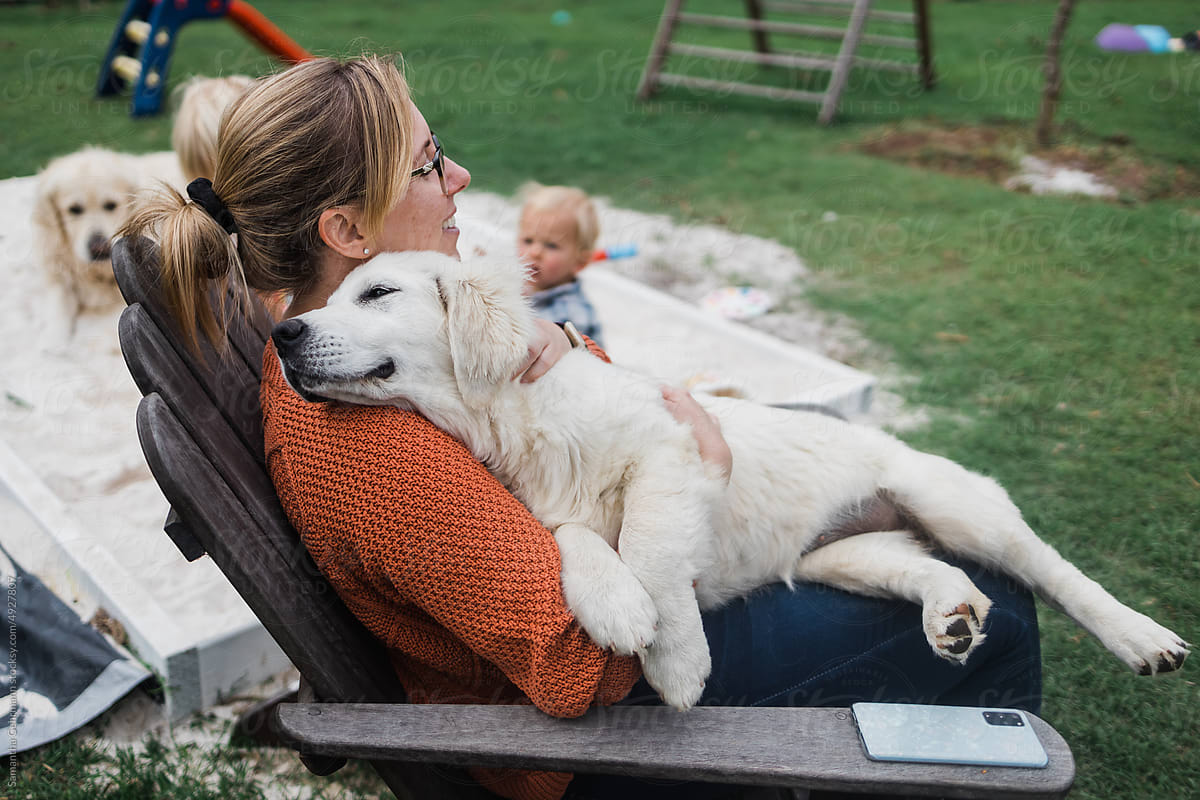 woman cuddling golden retriever puppy