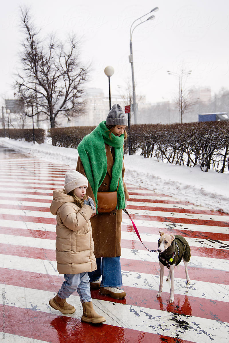 Mother and daughter walking with dog in winter