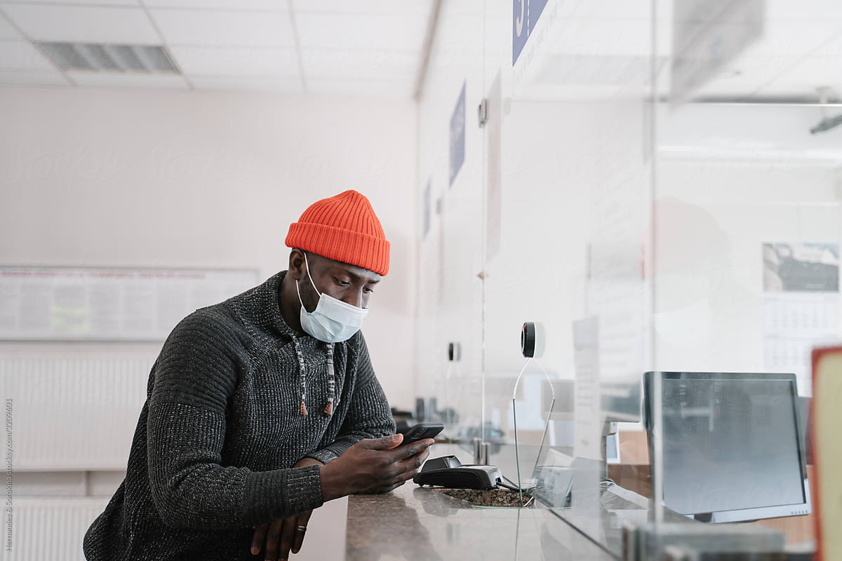 Black Man Wearing Face Mask Using Cellphone In The Station