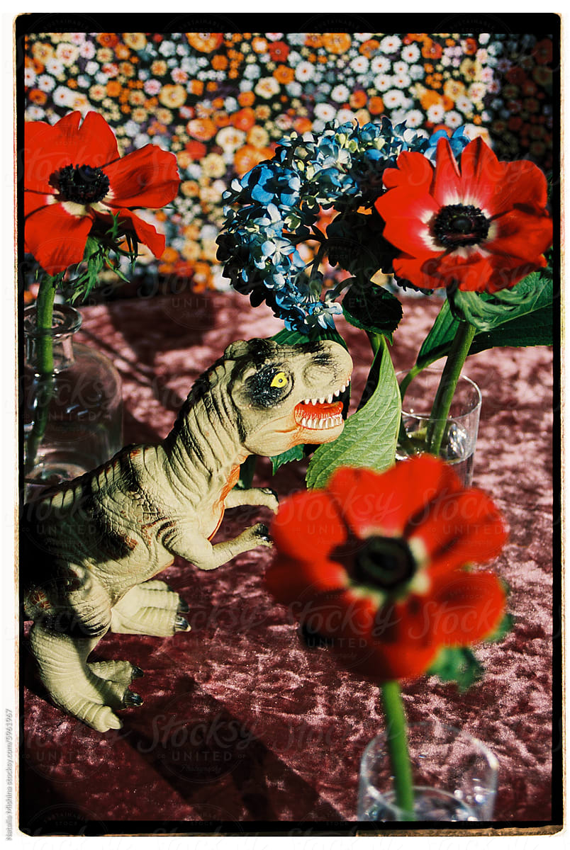 Conceptual art still life with toy dinosaur and anemones.