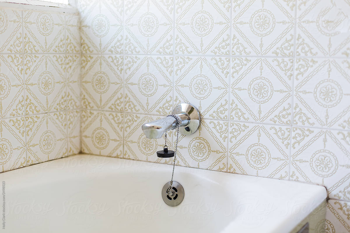 Faucet in vintage Bathroom with white and green tiles