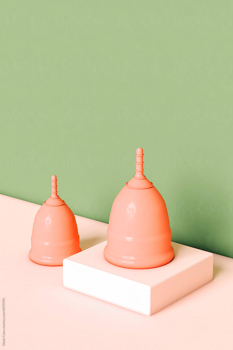 two pink Menstrual cups on pink and green background
