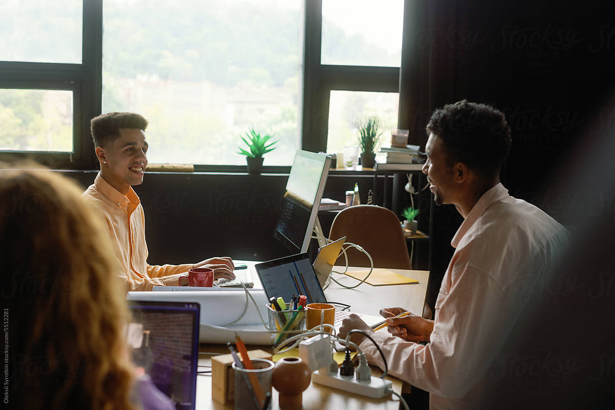 Team member small talk positive laptop shared workplace conversation