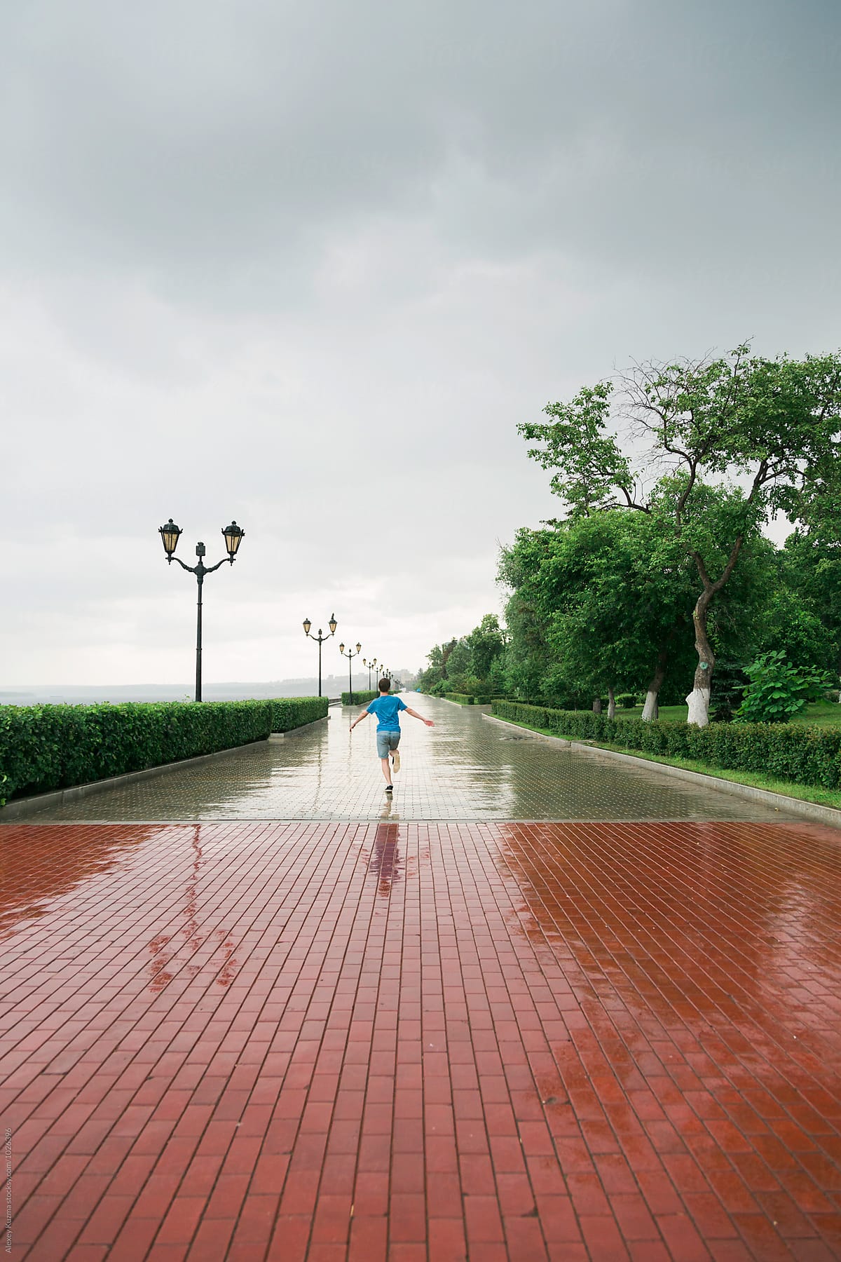 Happy Young Man Running Under Rain By Stocksy Contributor Alexey Kuzma Stocksy