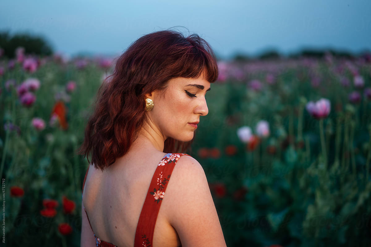 Moody Portrait Of Redhead Woman Among The Flowers