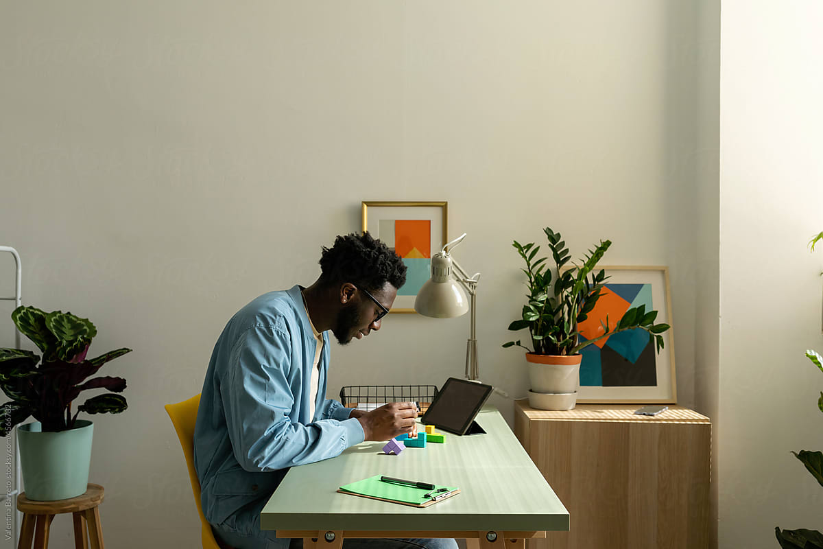 Black man assembling puzzle in cool office