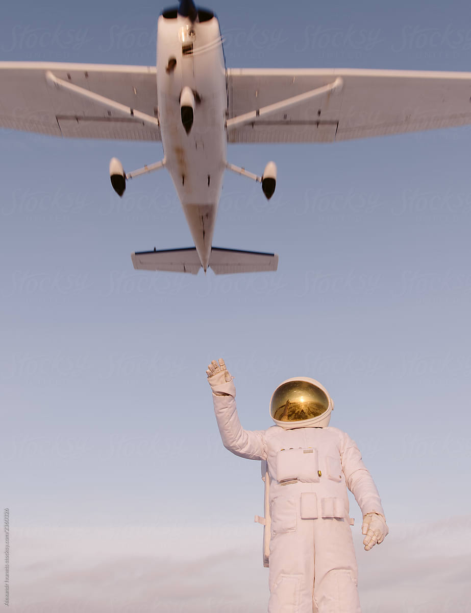Astronaut reaching out flying aircraft