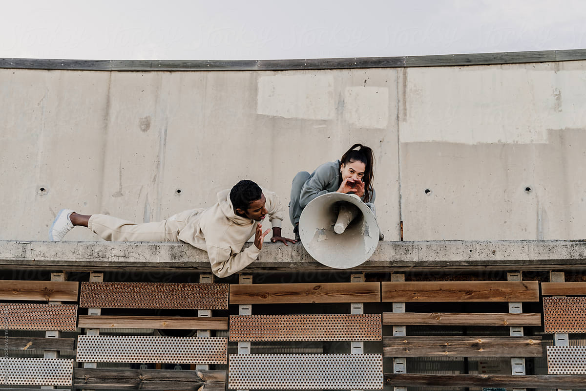 Woman talking on megaphone on top of wall