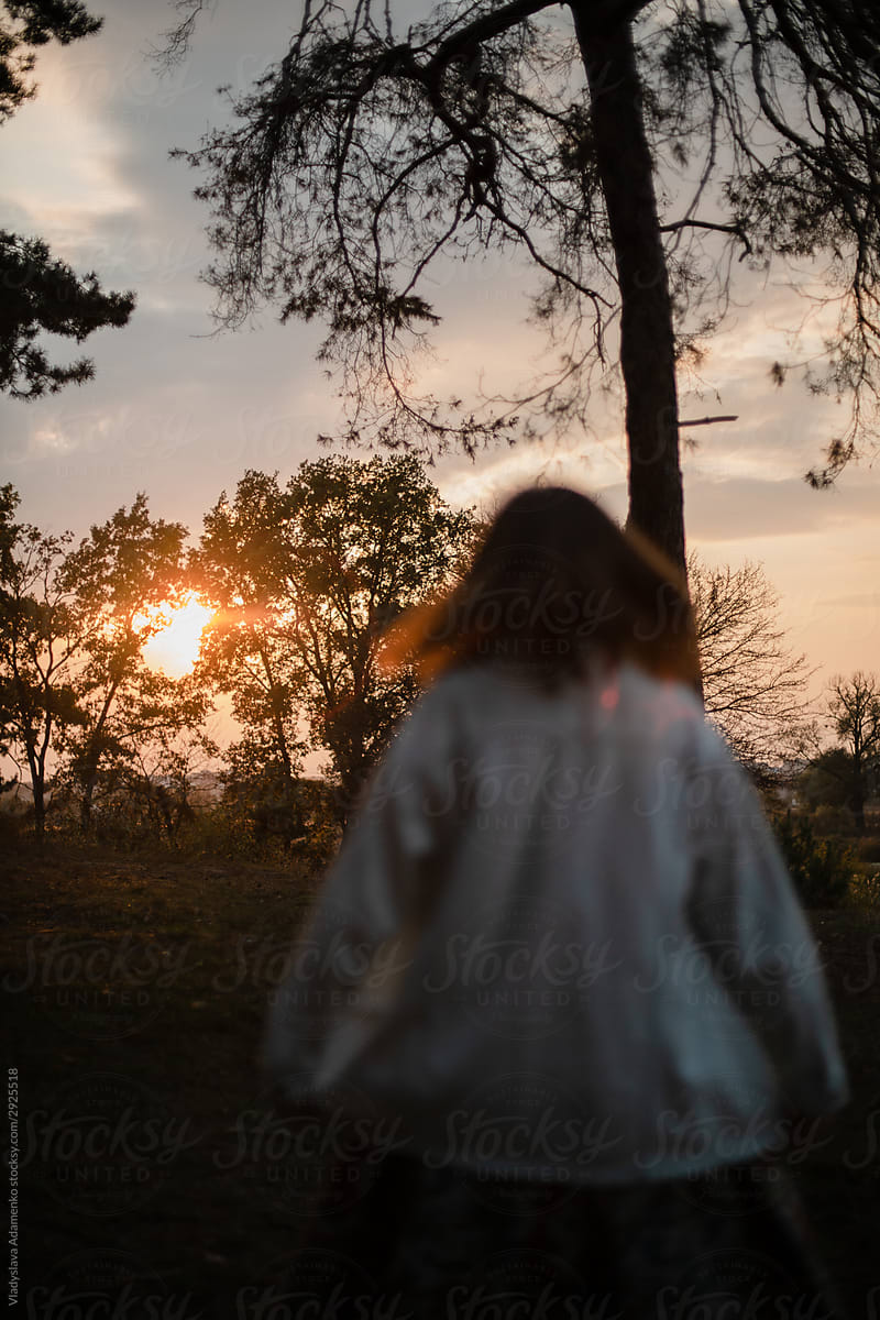 Girl dancing at the sunset in the woods