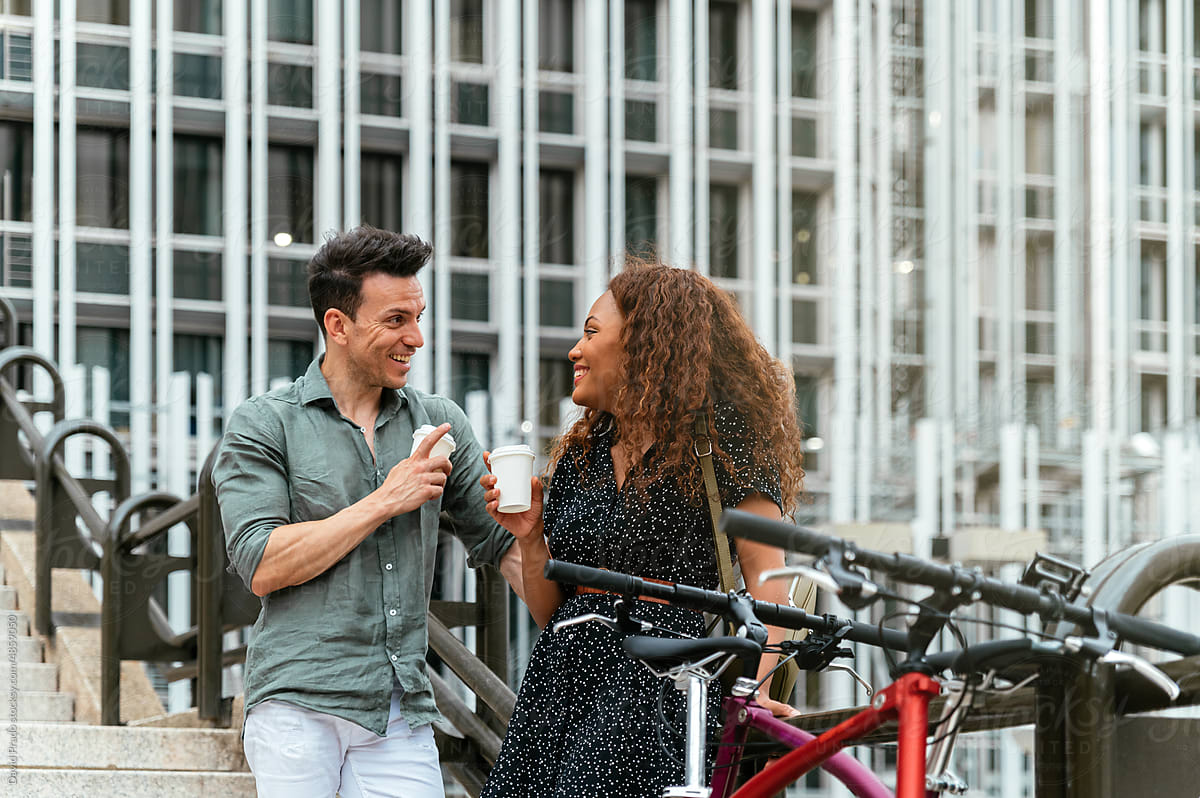 Multiracial couple drinking coffee on street