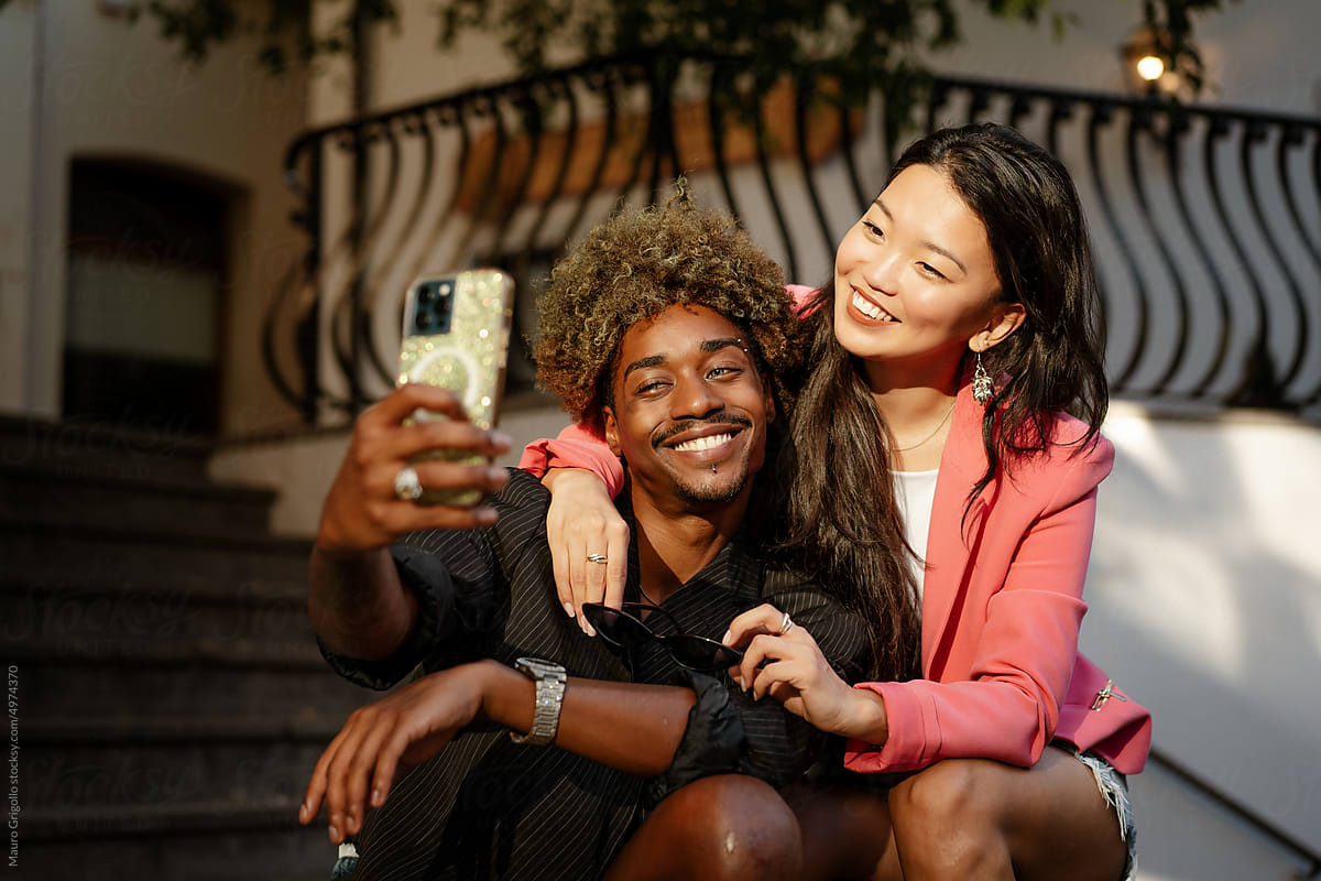 Smiling friends take a selfie with a smartphone