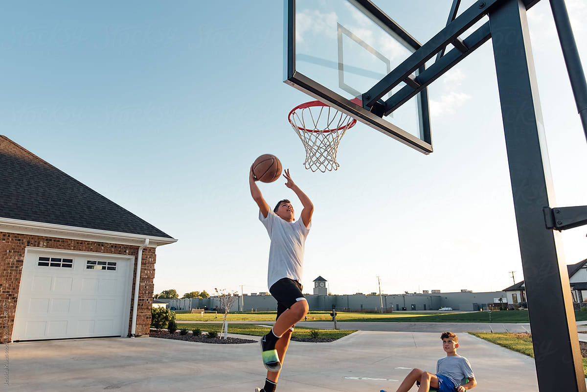 Teenager attempting a layup with basketball.