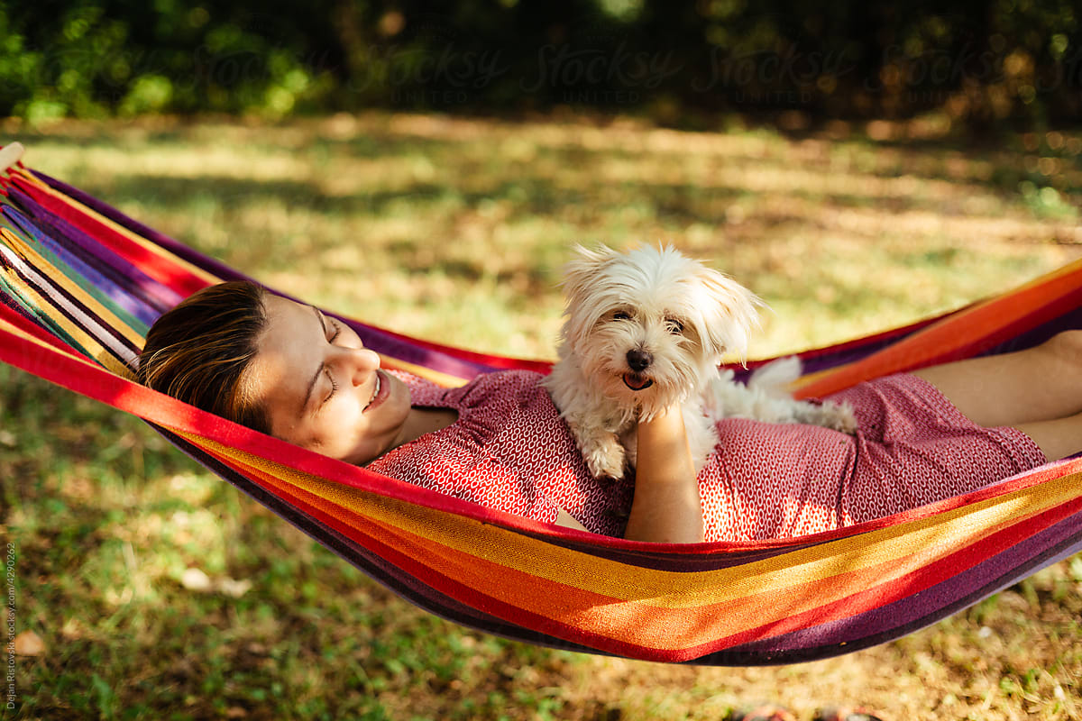 Woman and dog rest in a hammock