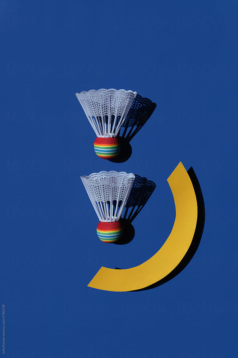 Two badminton shuttlecocks with geometric details on blue background