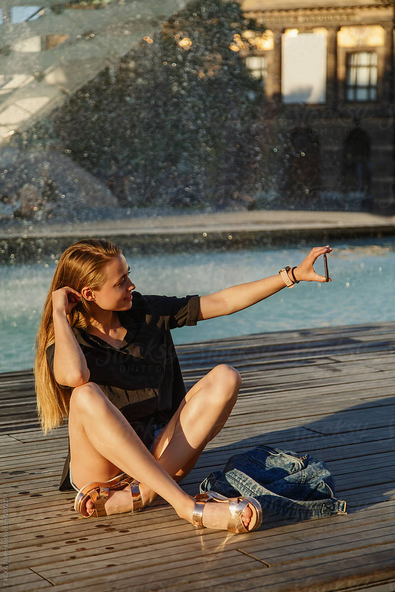 Pretty woman posing for selfie at fountain