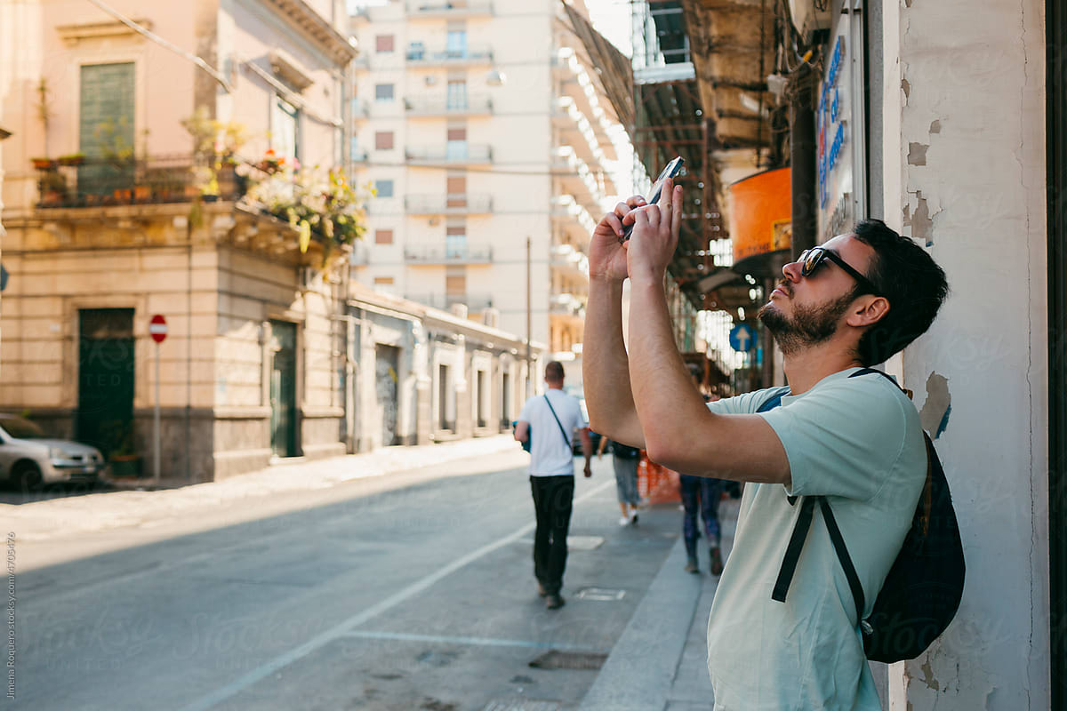 Tourist taking a photo on his smartphone in Italian city in warm day