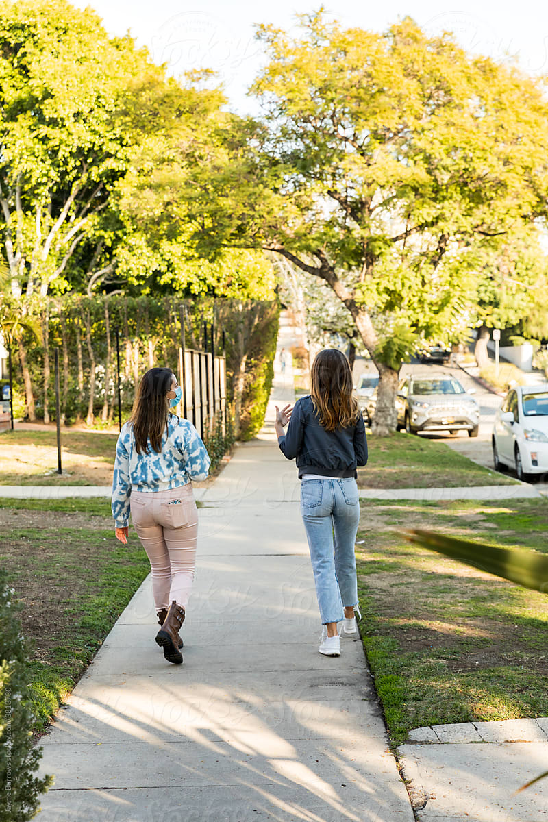 Female Friends Walk and Talk 6 Feet Apart Outdoors