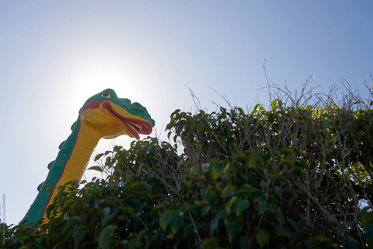 Toy dinosaur behind a bush