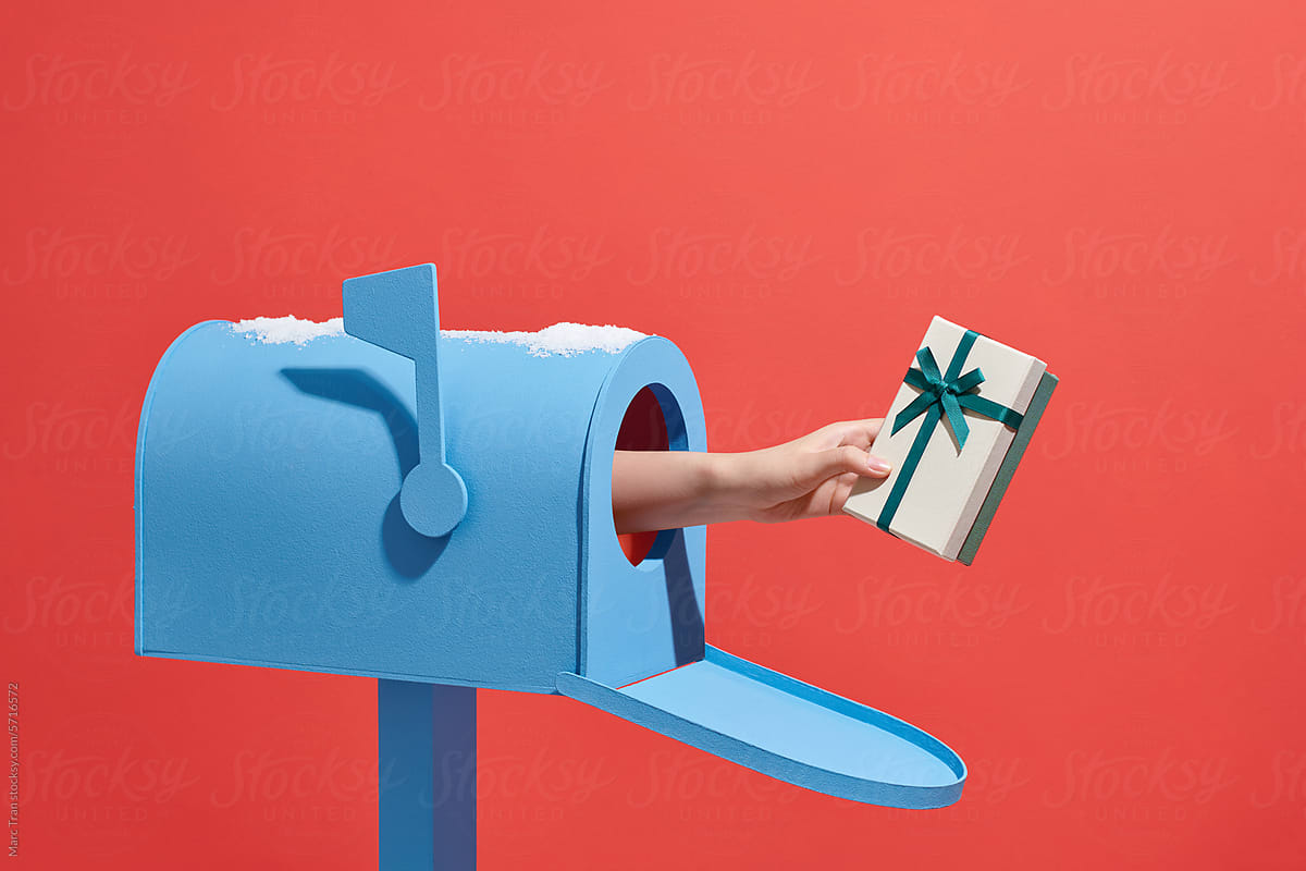 Human hand is taking out a gift box from a mailbox