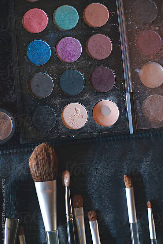 A palette of colourful eye shadows and brushes