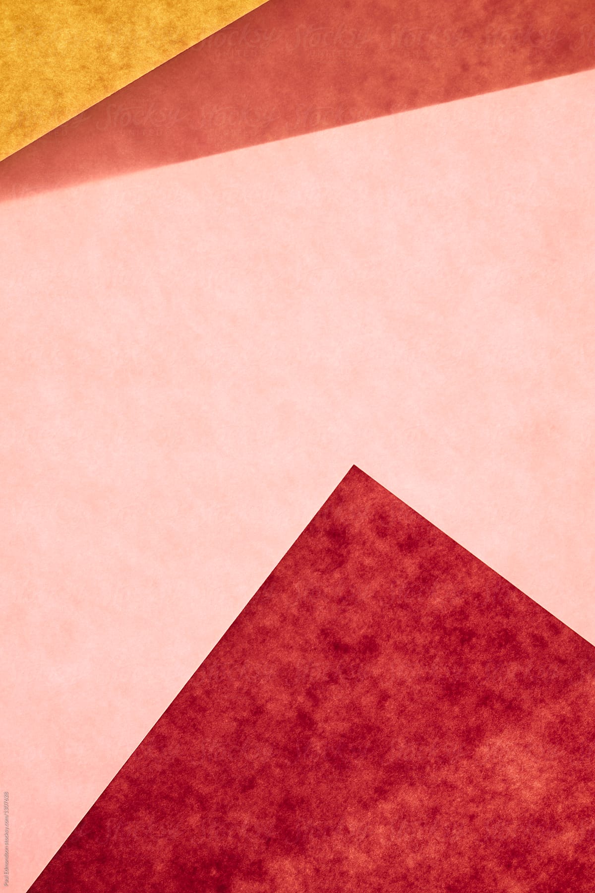Detail of pink and yellow sheets of recycled construction paper