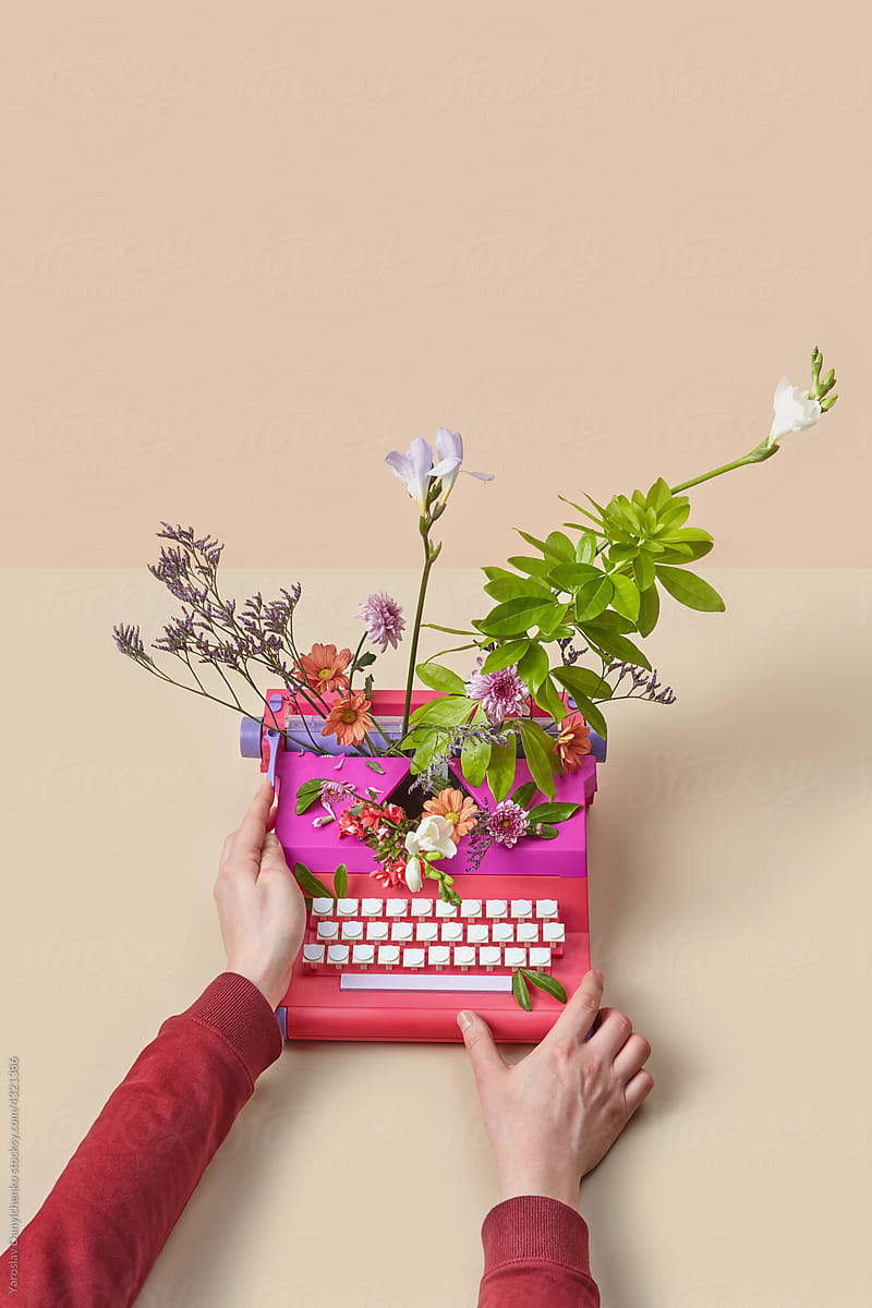 Male hands typing in vintage typewriter with flowers