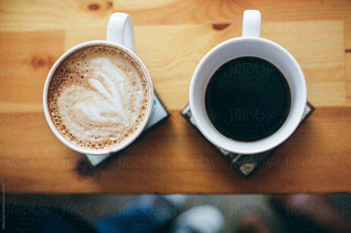 Overhead View Of Two Mugs Of Coffee On A Wooden Background." by Stocksy  Contributor "Holly Clark" - Stocksy