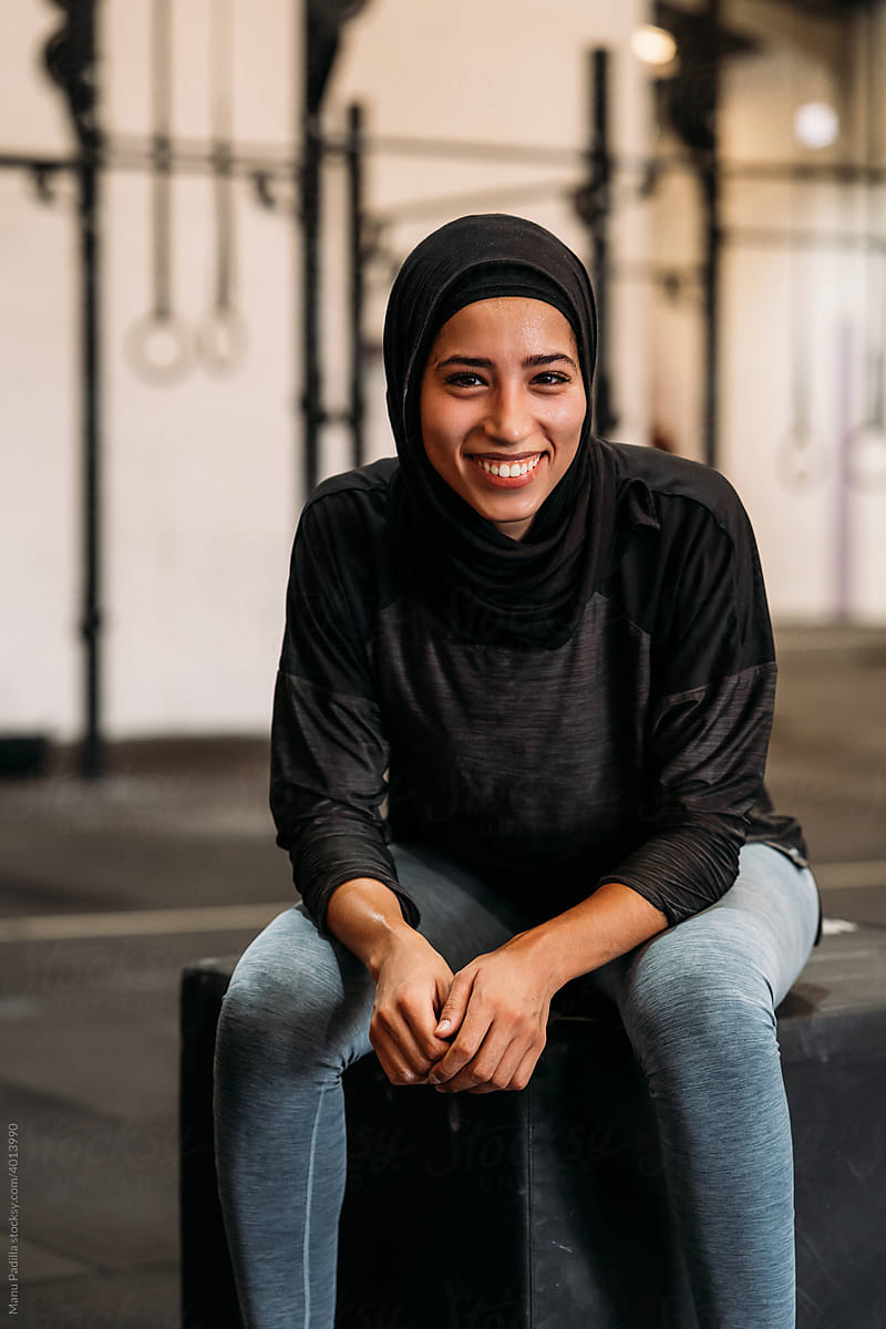Content Muslim woman sitting in modern gym