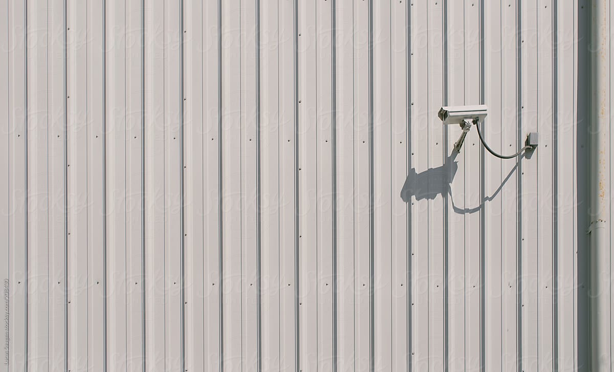 Security camera watches over the outside of a building.