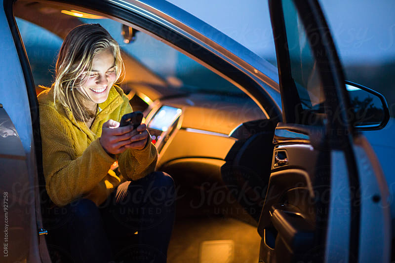 Young Adult Woman Texts from Car at Night