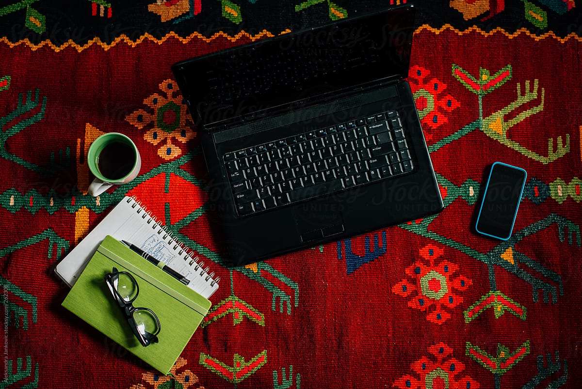 Laptop Computer With Objects On The Colorful Rug