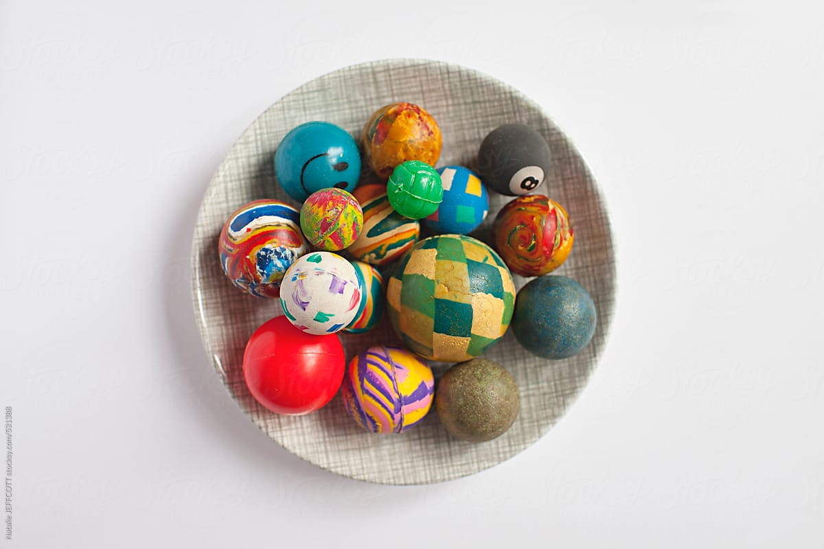 a collection of old retro rubber bounce balls in a dish