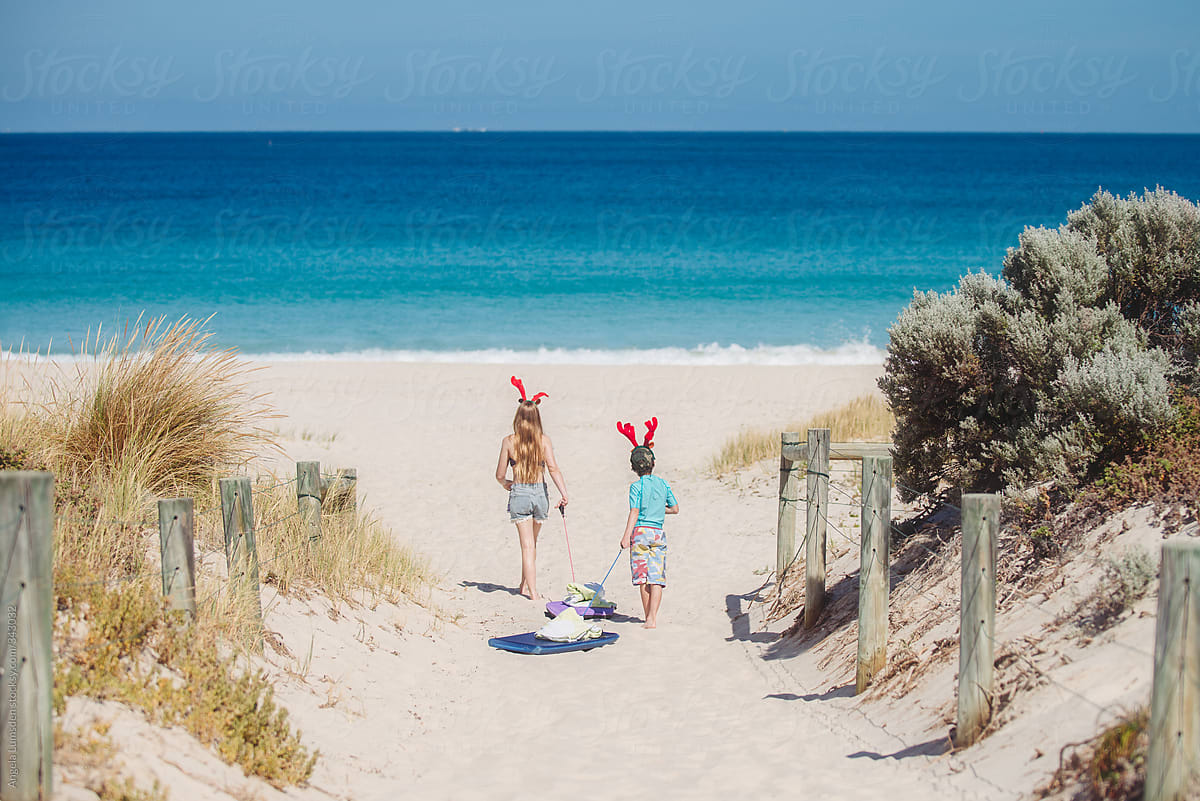 Two children walk to the beach on Christmas morning