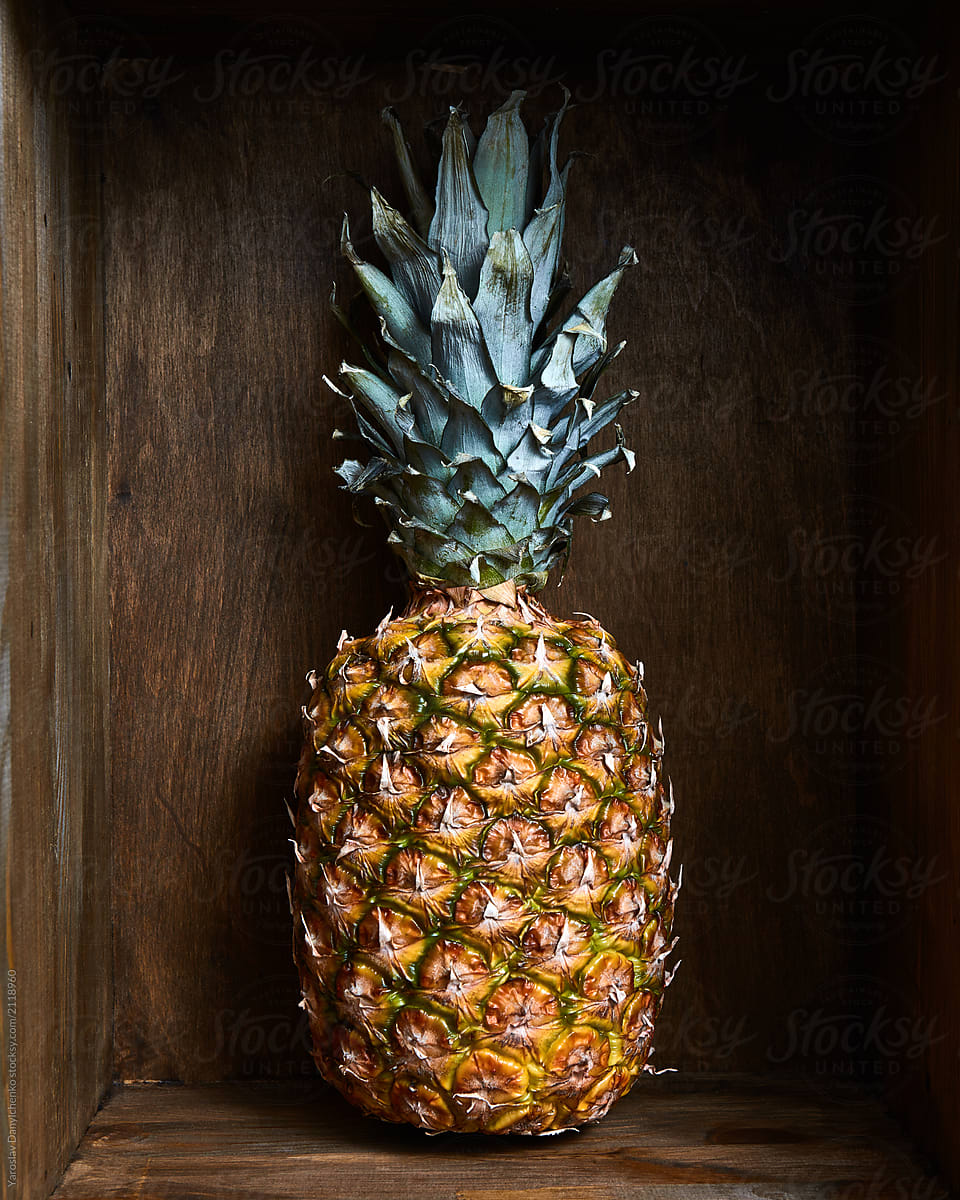 Ripe juicy pineapple fruit in a wooden vintage old box, background.
