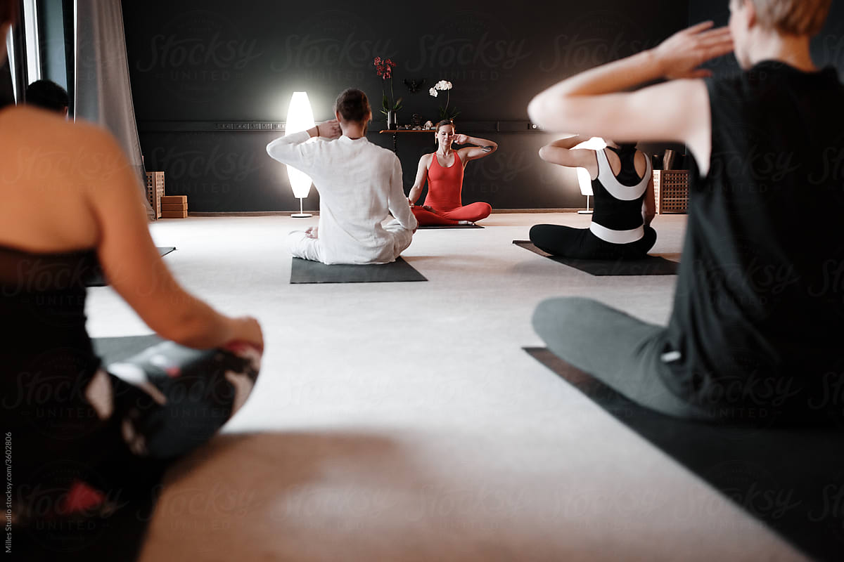 Group of people meditating with trainer in studio