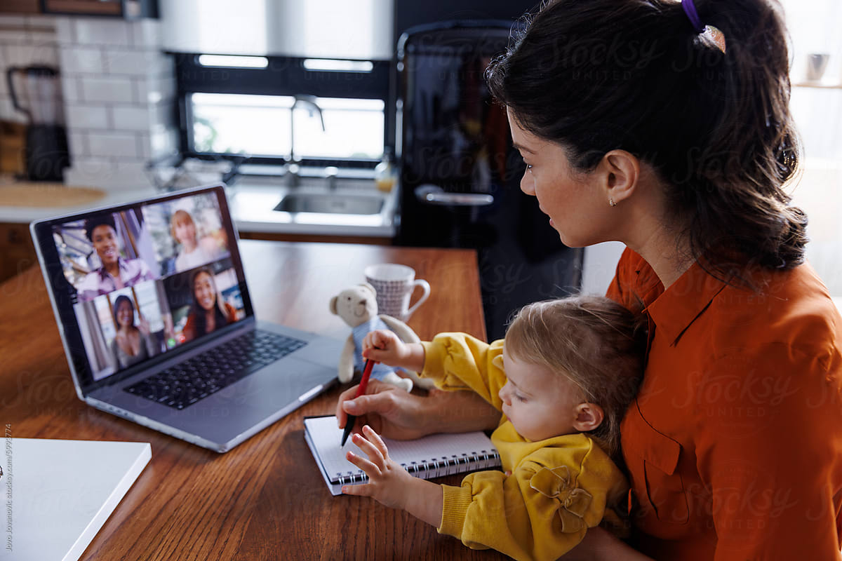 Working mother with daughter during video conference