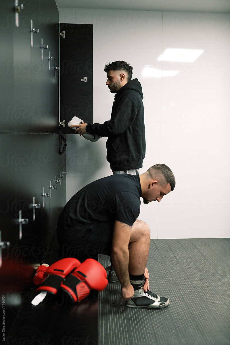 Male athletes getting ready for training in locker room